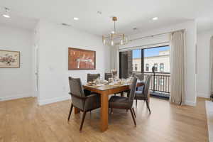 Dining space with suspended lighting and light wood-style floors