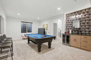 Playroom with billiards, wine cooler, light colored carpet, recessed lighting, and bar