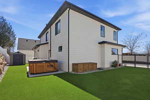 Back of house featuring a hot tub and a shed