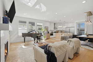 Living room featuring a fireplace, light wood-style flooring, and recessed lighting