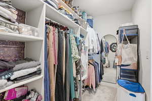 Walk in closet featuring light colored carpet