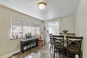 Dining room with wood finished floors and a textured ceiling