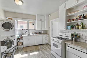 Kitchen featuring light countertops, white appliances, white cabinetry, and light wood-style floors