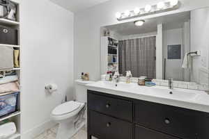 Bathroom featuring double vanity, a shower with curtain, and electric panel