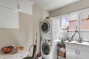 Laundry room featuring cabinet space and stacked washer / drying machine