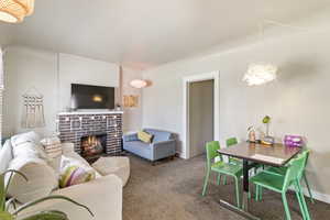 Living room featuring a fireplace, carpet floors, and a chandelier
