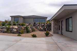 View of home's exterior featuring stucco siding, stone siding, and a patio area