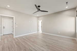 Empty room featuring a ceiling fan, wood finish floors, and recessed lighting