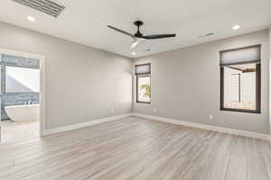 Spare room featuring light wood-type flooring, ceiling fan, and recessed lighting