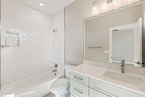 Bathroom with vanity, shower / bath combination, and recessed lighting