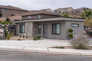 View of front of home featuring stucco siding and stone siding