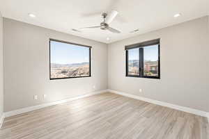 Spare room featuring light wood finished floors, ceiling fan, and recessed lighting