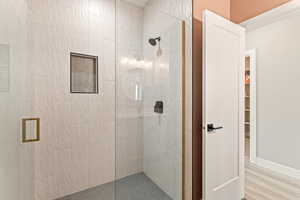 Bathroom featuring a shower stall and light wood-style flooring