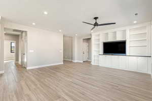 Unfurnished living room with light wood-style floors, a ceiling fan, built in features, recessed lighting, and a textured ceiling