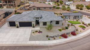 View of front of property with stone siding, an attached garage, driveway, stucco siding, and a tile roof
