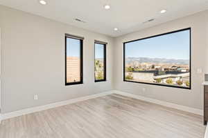 Unfurnished room featuring light wood-style flooring, recessed lighting, and plenty of natural light