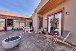 Patio featuring outdoor dining area, stained stamped concrete, and built in outdoor fire pit