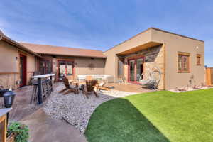 Rear courtyard featuring doors to inside, bar seating, and outdoor lounge area