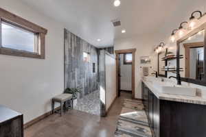 Primary ensuite bath with double vanity, travertine countertop and a walk in shower