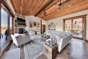 Living area featuring Alder tongue & groove ceiling, stone fireplace, and sliding glass doors to back patio
