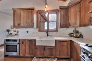 Kitchen featuring light Quartz countertops, and Apron sink with pull down faucet