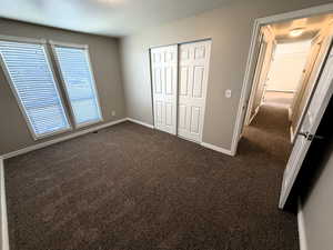 2nd upstairs bedroom featuring dark carpet and a closet