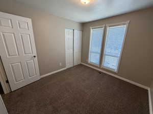3rd upstairs bedroom featuring dark carpet and a closet