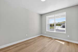 Unfurnished room featuring baseboards and light wood-type flooring