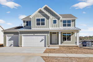 View of front of property featuring a porch, board and batten siding, concrete driveway, and a shingled roof
