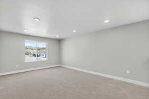 Carpeted empty room featuring recessed lighting