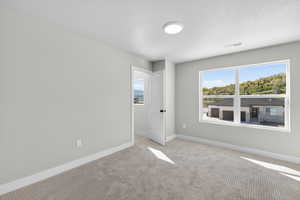 Empty room with baseboards and light colored carpet