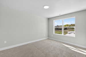 Carpeted spare room with baseboards