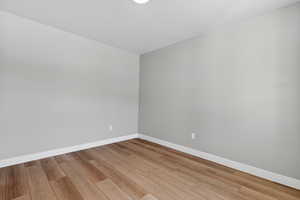 Unfurnished room with baseboards and light wood-type flooring
