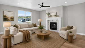 Spacious living area featuring light-toned walls, wood-finish flooring, and a contemporary ceiling fan