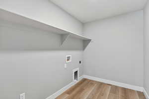 Laundry room with light wood-style floors, hookup for a washing machine, and electric dryer hookup