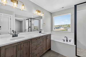 Full bath featuring a shower stall, double vanity, a garden tub, and dark tile patterned floors