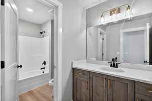 Bathroom featuring vanity, light wood-style flooring, and washtub / shower combination