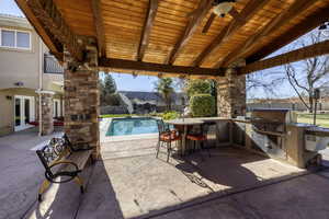 Fenced backyard featuring area for grilling, a patio, ceiling fan, french doors, and an outdoor pool