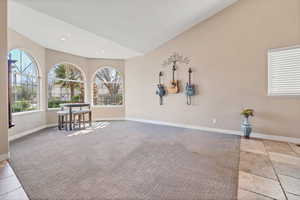 Spare room with light colored carpet, lofted ceiling, and recessed lighting