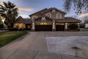 Mediterranean / spanish home featuring concrete driveway, a tiled roof, stone siding, and stucco siding