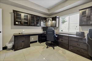 Office area featuring built in study area and light tile patterned floors