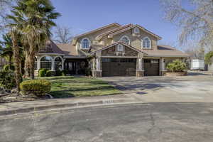 Mediterranean / spanish house with a tile roof, driveway, stone siding, stucco siding, and a garage