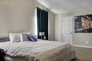 Bedroom with carpet floors and vaulted ceiling