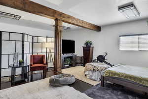 Bedroom with beam ceiling and wood finished floors