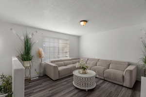 Living area featuring a textured ceiling and wood finished floors