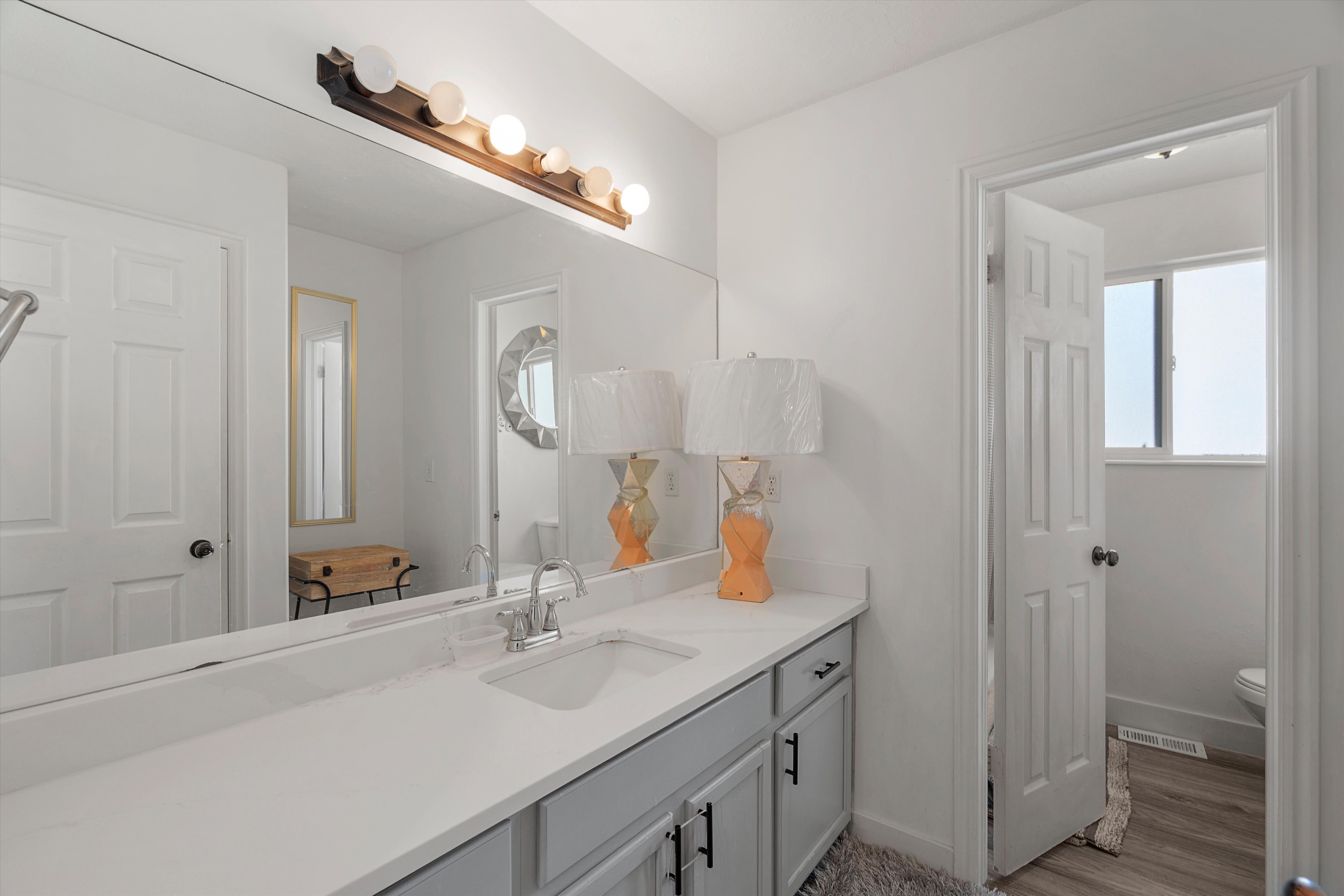 Full bath with vanity and light wood-style floors