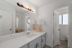 Full bath with vanity and light wood-style floors