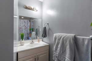 Bathroom with vanity and curtained shower
