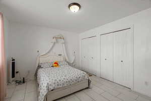 Bedroom featuring multiple closets and baseboards