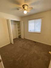 Unfurnished bedroom #3 with dark carpet, ceiling fan, and a closet